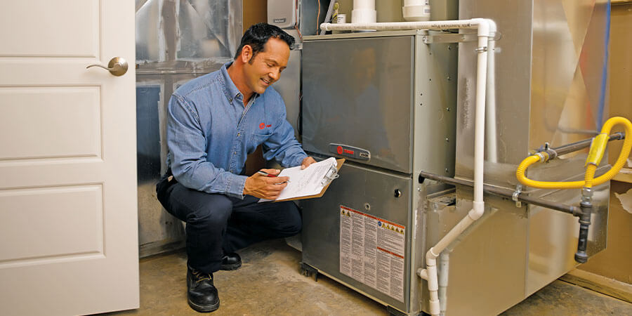 Trane technician inspecting heater installation